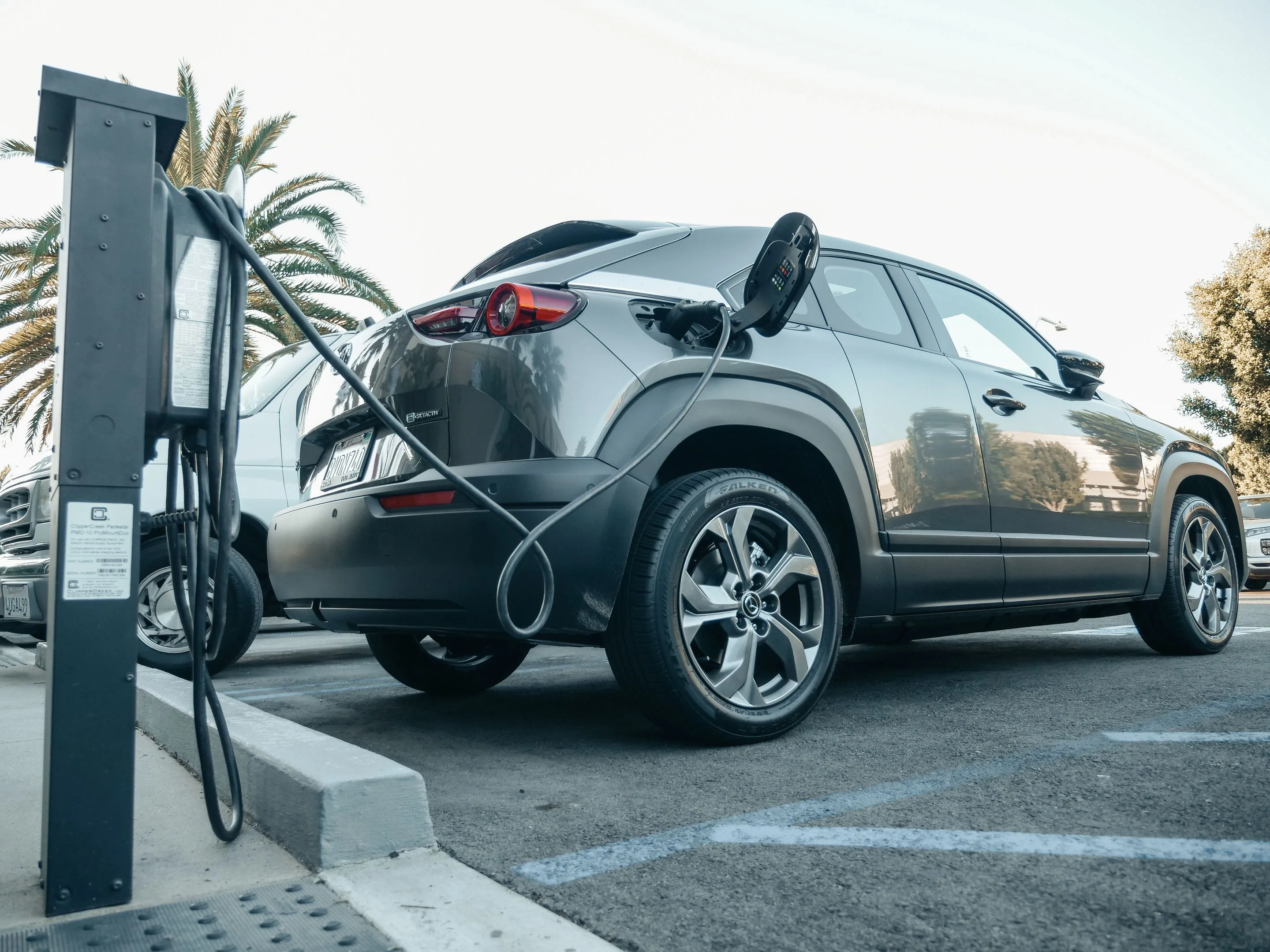 SUV électrique branché à une borne de recharge sur un parking extérieur