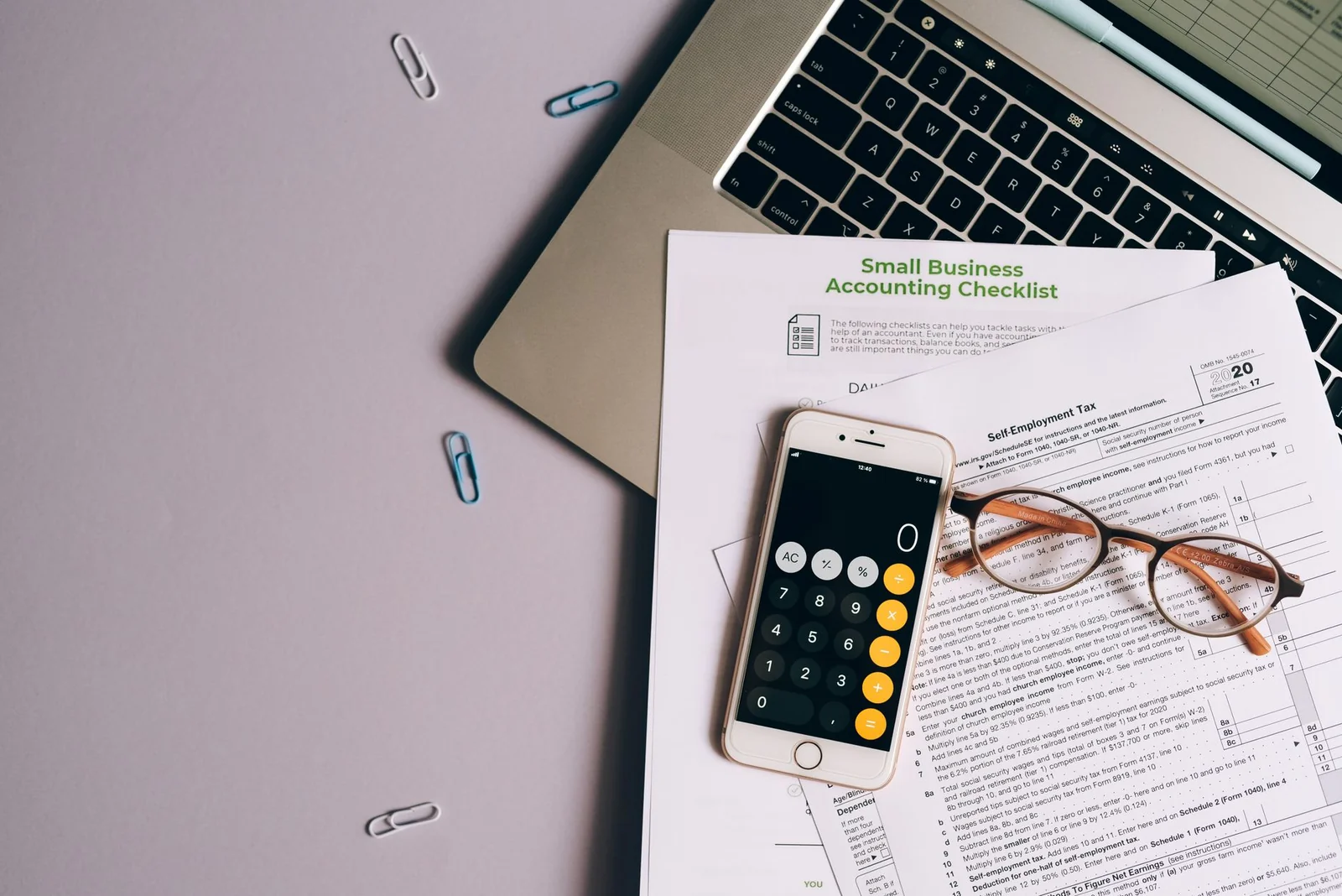 Calculatrice, documents fiscaux et ordinateur portable sur un bureau